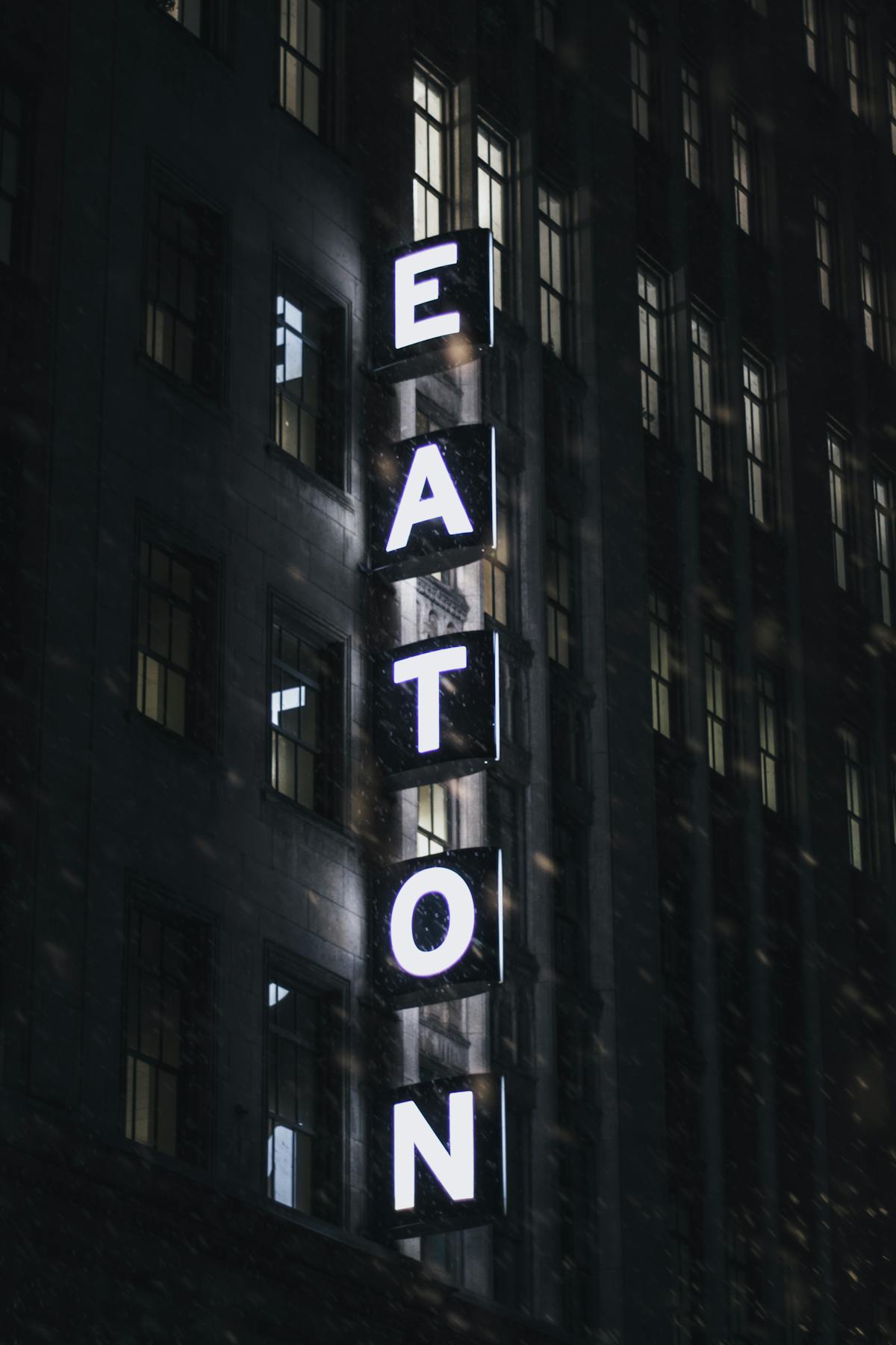 Eaton building sign illuminated at night with snowflakes